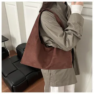 Détails du sac cabas en daim marron foncé avec bandoulière intégrée et texture douce