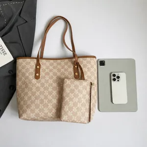 Vista plana de un conjunto de bolso tote beige con estampado de monograma y estuche