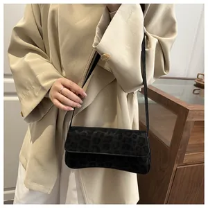 Detail view of stylish leopard print shoulder bag in black textured suede finish