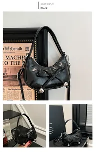 Detailansicht schwarze Mondtasche aus Lackleder mit Schleife und Silberperlen
