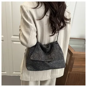 Détail du grand sac cabas gris foncé texturé avec bandoulière chaîne sur le mannequin