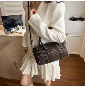 Detail of dark brown leather square bag featuring white contrast stitching and top handle