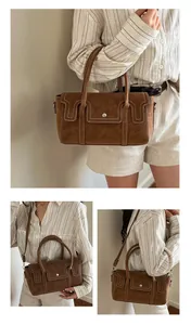 Detail of vintage brown crossbody bag with contrast stitching and silver metal buckle