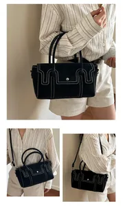 Detail view of black handbag showing white stitching and silver snap button closure