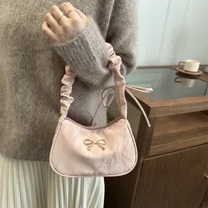 Borsa a mano plissettata rosa con fiocco metallico e tracolla scrunchie elegante
