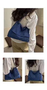 Détail d'un grand sac cabas en denim bleu avec bandoulière chaîne et rabat vintage
