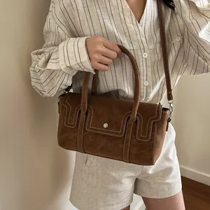 Brown suede crossbody handbag for women with white stitching and top handle detail