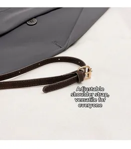 Detail van verstelbare donkerbruine riem met gepolijste goudkleurige metalen gesp