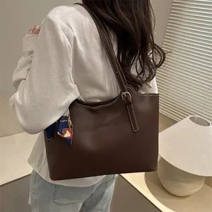 Brown minimalist tote bag with white contrast stitching and floral silk scarf accessory