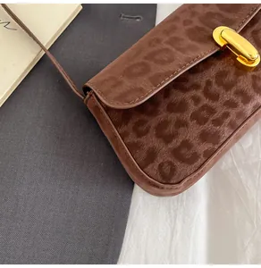 Nahaufnahme der Leoparden-Baguette-Tasche mit strukturiertem Stoff und goldener Schließe