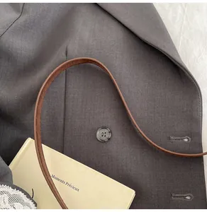 Detailansicht des dunkelgrauen Blazermaterials mit feiner Twill-Textur und Harzknopf