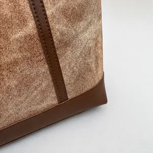 Detailed macro view of textured canvas fabric with premium brown leather stitching trim