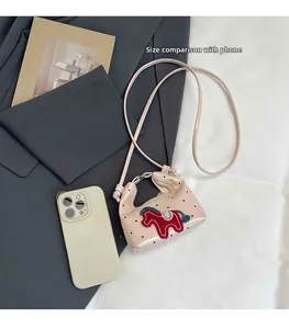 Nahaufnahme der rosa gepunkteten Minitasche mit Pferdeaufnäher und Handy zum Größenvergleich