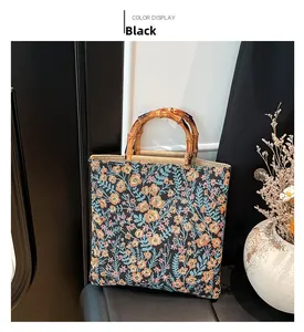 Detalle del bolso tote de jacquard floral con asas de bambú marrón en negro