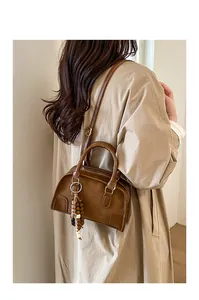 Dettaglio di una borsa Boston vintage marrone smerigliato con ciondolo in perline di legno