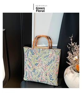 Primer plano detallado de un bolso tote de flores verdes con asa de bambú natural