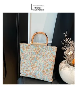 Detalle del bolso tote de algodón y lino con flores naranjas y asas de bambú