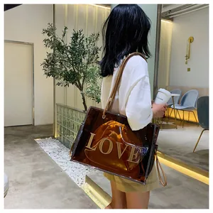 Detailed shot of large transparent brown tote bag with LOVE logo and inner pouch