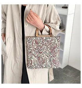 Detail der Vintage-Shopper mit Blumenmuster, Bambusgriffen und feiner Jacquard-Stoffstruktur