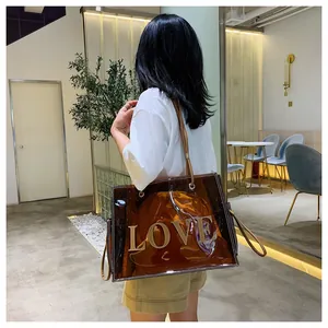 Detail of transparent brown PVC tote bag with leather straps and yellow drawstring inner pouch
