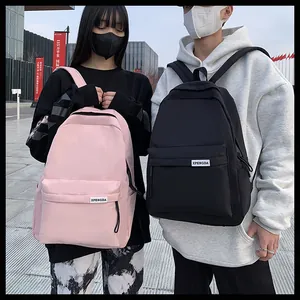 Dettaglio di zaini in nylon rosa e nero con logo XPENODA su sfondo urbano di strada