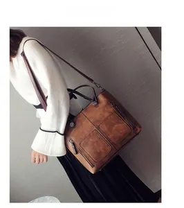 Detail of vintage brown PU leather bag showing two front zip pockets and retro metal hardware