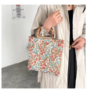 Detailaufnahme der Vintage-Tragetasche mit floralem Segeltuch und echten Bambusgriffen