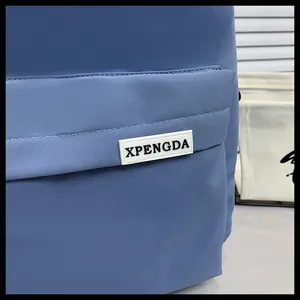 Primo piano dello zaino in nylon blu con texture del tessuto resistente e logo cucito
