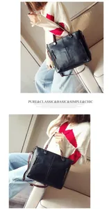 Detail view of black vintage PU leather handbag with dual front pockets and metal zippers