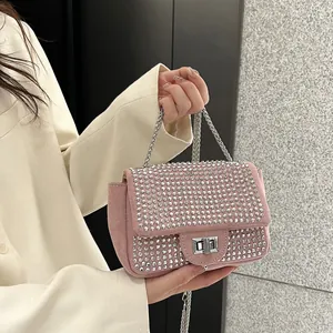 Close-up of pink rhinestone crossbody bag with silver metal chain and twist lock