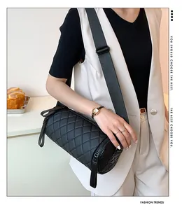 Detail view of quilted cylinder bag with wide strap and fashion marketing text