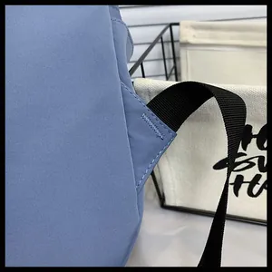 Dettaglio della cucitura a triangolo rinforzata sugli spallacci dello zaino in nylon blu