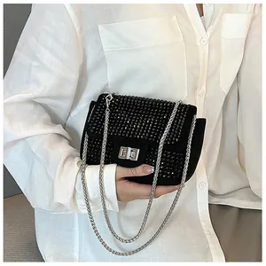 Detail of black rhinestone crossbody bag with silver twist lock and metal chain strap