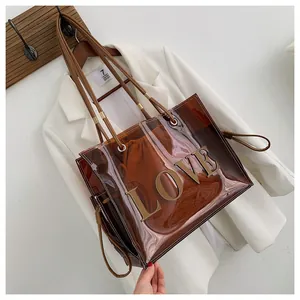 Detail of transparent brown PVC tote bag with leather LOVE patch and inner drawstring pouch