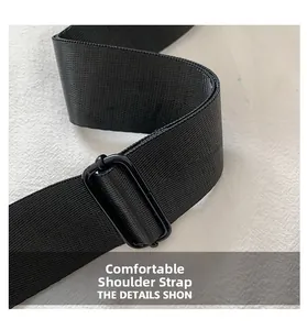 Detail of adjustable wide black woven shoulder strap with matte buckle for cylinder bag