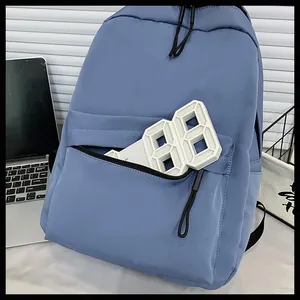 Dettaglio della tasca frontale con cerniera e del tessuto in nylon opaco dello zaino blu