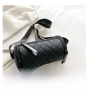 Detailed top view of a black quilted barrel bag with a smartphone for size reference