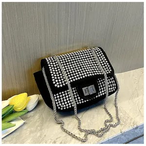 Detail of black suede evening bag featuring sparkling rhinestones and silver chain strap