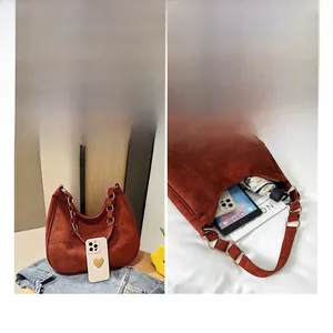 Detailweergave van steenrode suède hobo tas met ruimte voor tablet en dagelijkse spullen