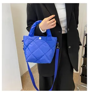 Modellansicht der hellblauen gesteppten Beuteltasche mit Umhängeriemen und Knopf