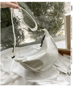 Primer plano del elegante bolso bandolera de nailon blanco roto con forma de media luna
