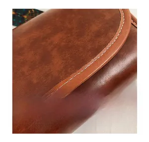 Vue détaillée des surpiqûres blanches sur le sac en cuir texturé marron chic