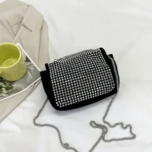 Macro shot of black suede square bag with silver rhinestones and metal chain