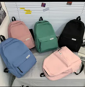 Vista piatta di zaini colorati in nylon impermeabile in rosa, verde, blu e nero
