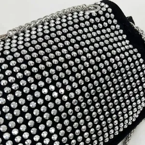 Detailed close-up of sparkling silver rhinestones on luxury black evening clutch bag