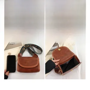 Vue détaillée du sac bandoulière en cuir marron avec sangle jacquard et intérieur spacieux