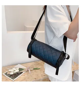 Detailed view of the quilted cylinder crossbody bag with wide strap and zip closures