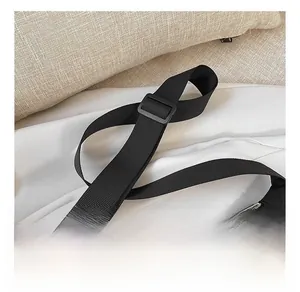 Detail of adjustable wide shoulder strap and durable zipper on a black nylon crossbody bag