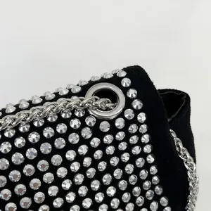 Close-up of black velvet crossbody bag featuring sparkling silver rhinestones and chain strap