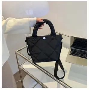 Detailansicht der schwarzen Stepptasche mit Falten-Griff und Metall-Druckknopf